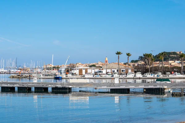 Saint Tropez view from far away with palm trees water and blue sky in day time