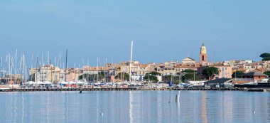 Saint Tropez view from far away with palm trees water and blue sky day time
