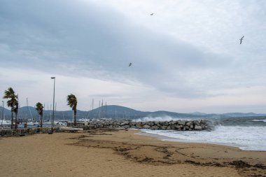 Port Cogolin beach shore rainy day with wind and clouds