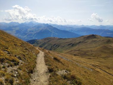 Dağlık bir arazinin sakin bir sahnesi, otlak yaylası ve bulutlarla kaplı yemyeşil bir vadi. Doğadaki güzelliğin mükemmel bir örneği..