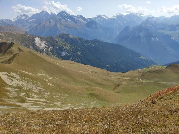 Dağlık bir arazinin sakin bir sahnesi, otlak yaylası ve bulutlarla kaplı yemyeşil bir vadi. Doğadaki güzelliğin mükemmel bir örneği..