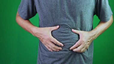 Şişman adam göbeğini sıkıyor, obezite, elleri karnını sıkıyor, şişman adam krom anahtar yeşil ekranda, 4k video.