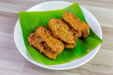 Beyaz bir tabakta muz yaprağında servis edilen kızarmış Tayland muzu, tatlı ve çıtır çıtır dokulu geleneksel Asya atıştırmalığıdır. Üst görüntü görüntüsü