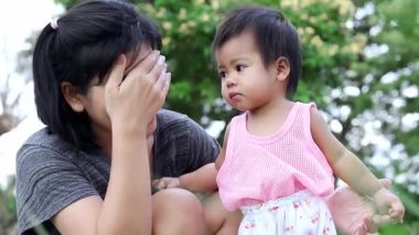 Anne ve bebek dışarıda mutlu bir şekilde oynuyorlar, sevgi gösteriyorlar, kaynaşıyorlar, mutlu anne ve bebek aktiviteleri yapıyorlar, ve doğada neşeli bir aile ortamında sıcaklık var.