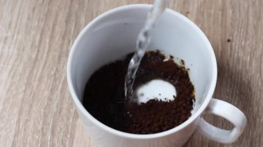 Sıcak suyu köpüklü beyaz bardakta siyah kahveye dökerek tazeliği, sıcaklığı ve enerjiyi çağrıştırıyor. Kafe, yaşam tarzı veya reklam içeriği için ideal