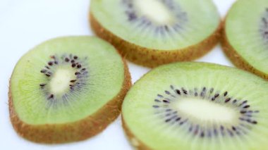 Yakın plan kivi, sulu bir kivinin makro görüntüsü tohumlarının ve dokusunun canlı detaylarını gösteriyor. Kivi besleyici ve ferahlatıcı bir meyvedir.