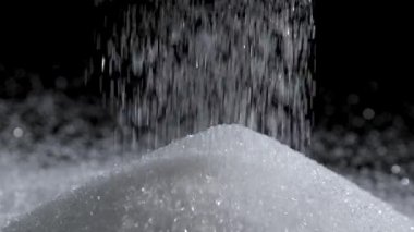 Şeker, yığın üzerine dökülen beyaz granüllü şeker aşırı şeker tüketimini, şeker hastalığını ve sağlık risklerini, sağlık farkındalığını, şekerli gıdalar için granüllü şekeri ve tatlı malzemesini sembolize eder.