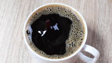 Sade kahve, bir damla sade kahve sıcak kahve bardağına çarptıktan sonra yukarı doğru sıçrıyor. İçki, yaşam tarzı ve hareketle ilgili görseller için mükemmel bir yakın çekim.