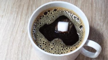 Sade kahve, şeker küpü, sıcak sade kahveye damlar, su sıçramasına ve dalgalanmalara neden olur. Zengin kahve desenli yakın çekim, içecek, yiyecek ve yaşam tarzı içeriği için ideal.