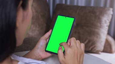 Dikey pozisyonda yeşil ekranlı akıllı telefonu tutan kadın, modelleme veya görsel ekleme için mükemmel, yakın çekim