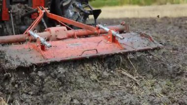 Traktör çamurlu pirinç tarlası, çeltik çamuru, tarımdan sonra tarımda toprak dokusu ve tarım sürecini gösteriyor, yakın plan.