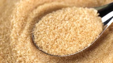 Granüllü esmer şeker, kaşık kepçeli kahverengi şeker tanecikleri, yakın plan, doku detaylarını gösteriyor. içecek yiyecek, malzeme ve tatlı konsepti için.