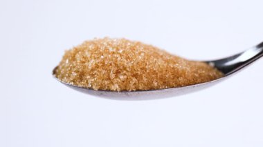 granulated brown sugar in spoon and pouring, sugar crystals, food material, sugar industry, dessert, culinary, nutrition, sweetness, risk of diabetes, sugar control, health awareness