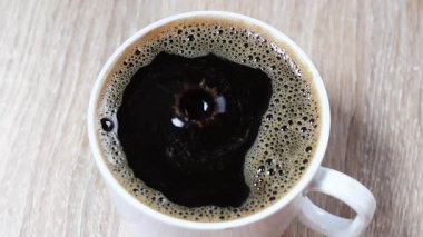 Sade kahve, bir damla sade kahve sıcak kahve bardağına çarptıktan sonra yukarı doğru sıçrıyor. İçki, yaşam tarzı ve hareketle ilgili görseller için mükemmel bir yakın çekim.