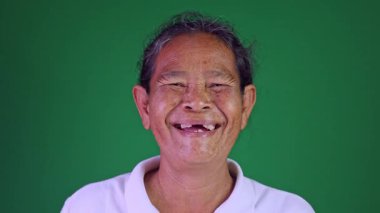 Elderly face woman laughing happy, Portrait elder with facial expression, Close-up portrait grandmother smiling happily on chroma key green screen background, Thai asian