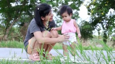 Anne ve bebek dışarıda birlikte vakit geçiriyorlar, anne ve bebek mutlu bir şekilde oyun oynuyorlar, mutlu anne ve bebek aktiviteleri, aşkı, sıcaklığı ve güçlü aile bağlarını temsil ediyorlar.