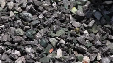 İnşaat çakılları, kaya, taş yığınları, inşaat veya çimento karıştırma sürecinde malzeme kullanımını gösteriyor