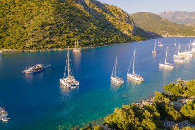 Laguna 'da kristal berrak turkuaz denizle demirli lüks yatların hava görüntüleri.
