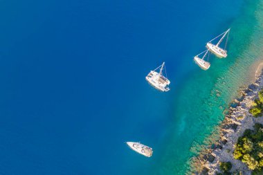 Turkuaz su Ege Denizi 'nde demirli yatın üst görüntüsü. Denizdeki lüks yatlarda tatil.