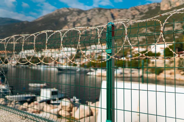 stock image Barbed wire at border at marina sea, close-up