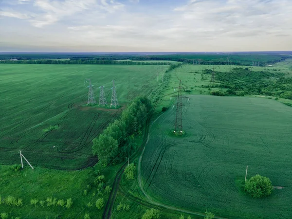 緑の農業風景の中に高電圧の電力塔空中ビュー ストックフォト