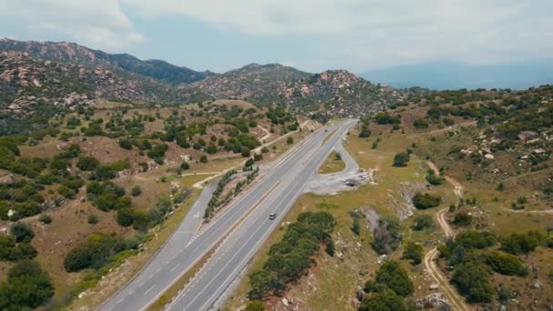 曲がりくねった丘や谷を通ってターンパイク高速道路のカット 州間輸送をテーマに 交通の緑の自然の田園地帯の航空追跡 — ストック動画