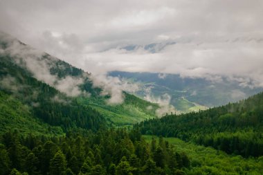 Bulutlu gökyüzünde dağların havadan görünüşü, hava görüntüsü
