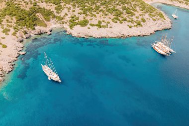 Akvaryum koyu Bodrum 'da lüks yelkenli yatları, yelkenlileri, berrak kristal su lagünü var. Hava görüntüsü
