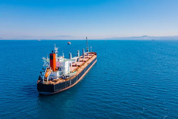 Bulk cargo carrier sea ship anchored in Aegean sea waiting entering port, Aerial view
