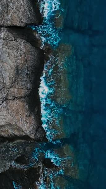 ロッキーなサンゴ礁と海岸の波の崖をクラッシュ 垂直上下のビュー — ストック動画