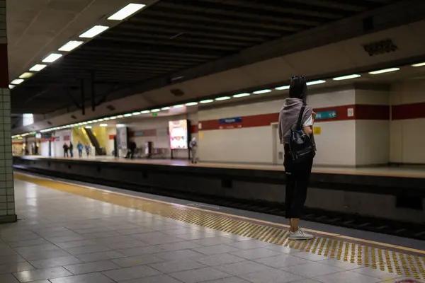 기차가 도착하는 여자가 지하철 역에서 기다립니다 — 스톡 사진