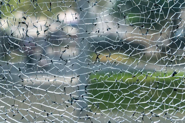 stock image Broken glass and blurred city background, vandalism in big city