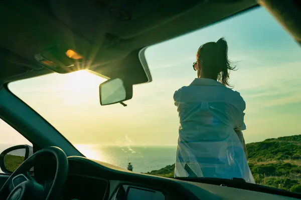 Escape from city of young woman by car enjoy of sunset, view from inside car