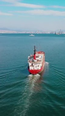 Kuru genel kargo gemisi limandan limana doğru yol alıyor. Toplu taşıma gemisi ya da bulker gemisi, dikey hava atışı.