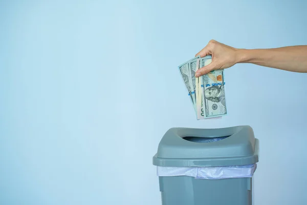 女性はゴミ箱にドルを入れました ゴミ箱の中のインフレコンセプトのお金 ロイヤリティフリーのストック写真