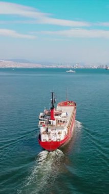 Kuru genel kargo gemisi limandan limana doğru yol alıyor. Toplu taşıma gemisi ya da bulker gemisi, dikey hava atışı.