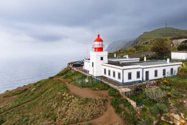 Madeira Ponto da Pargo 'nun batı kıyısındaki deniz feneri, okyanusun üzerindeki bir uçuruma tünemişti.