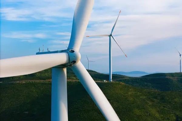 Yakın rüzgar türbini yeşil tepelerde, modern enerji santralinde ve alternatif enerji kaynaklarında enerji üretir.