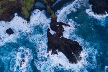 Fırtına sırasında Madeira Atlantik kıyısındaki kayalık resiflere okyanus dalgaları çarpar. Hava görüntüsü