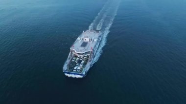 Araba feribotu sahil kenti arasında yol alıyor. Deniz lojistiği ve ulaşım. Hava görüntüsü. İzmir, Türkiye - 23 Ekim 2023