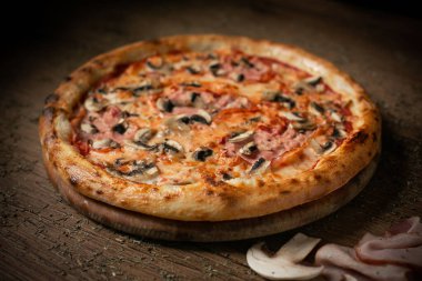 Sosisli ve mantarlı lezzetli tavuk pizzası. koyu ahşap masa arkaplan üstü alçak tuş