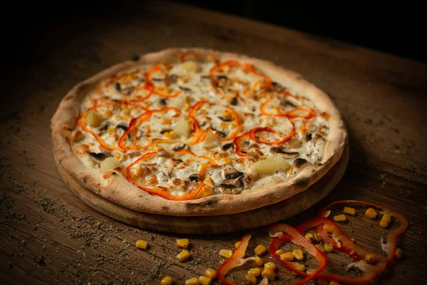 delicious chicken pizza with sausages and mushroom. dark wooden table background low key