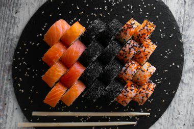 Çeşitli Japon suşi siyah arka plan üzerine alır. Asya veya Japonca gıda çerçeve