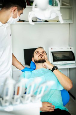 Mutsuz hasta adamın diş ağrısı var. Profesyonel kürsüde diş hekiminde.