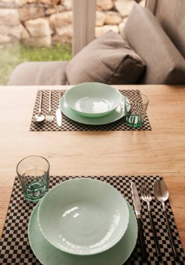 Boş kaseler, kaşıklar ve keten peçeteler, gri grunge arka plan. Üst manzara, düz yatış. Masa ayarı. Yeme konsepti. Desenli nesne, seçici odak.