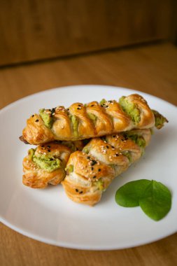 Beyaz tabakta ıspanaklı ve peynirli Türk çorbası. Geleneksel bir Türk hamur işi, Türkçe adı rulo borek veya sigara boregi.