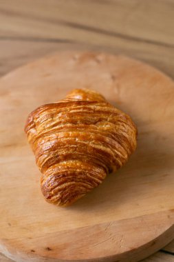 Ahşap arka planda gri bir tabakta kruvasan, üst manzara.