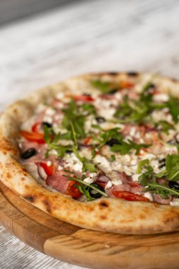 Ahşap masada jambonlu lezzetli peynirli pizza. Yakın çekim