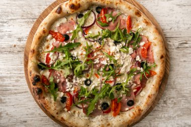 Ahşap masada jambonlu lezzetli peynirli pizza. en üstteki görünüm