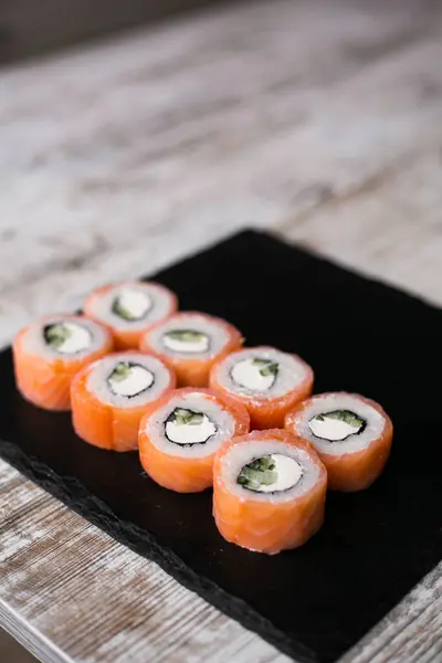 light salmon sushi philadelphia with onion on black desk white background with chopstick